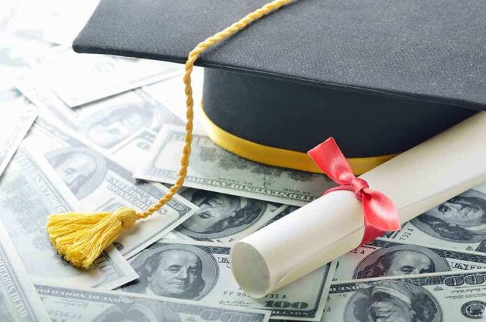 shutterstock_119968390.jpg Graduation cap and diploma resting on a pile of money