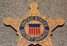 Golden badge of the United States Secret Service displayed on a surface