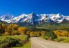 Ultimate Route 66 Party: A Year-Long Nostalgia Trip Scenic view of snow-capped mountains with autumn trees and a winding road