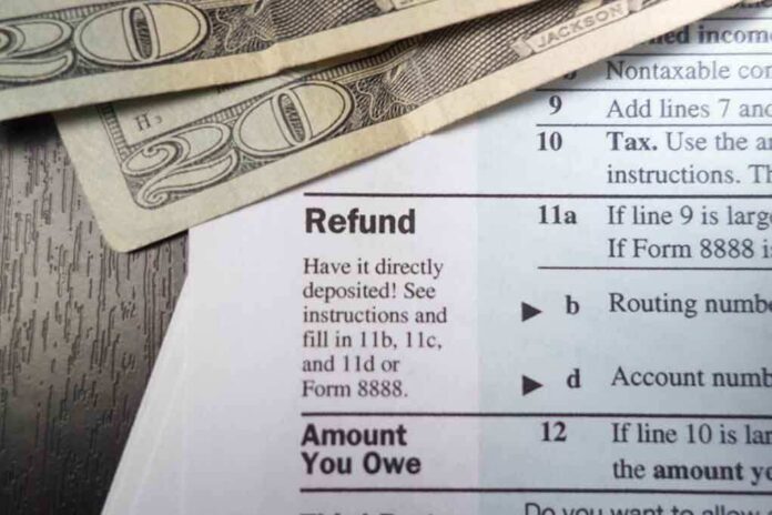 Close-up of tax refund form with cash on a wooden surface