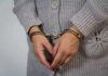 A person wearing handcuffs with their hands clasped together