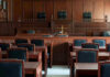 Shocking AI Lawsuit: ChatGPT Helped Shooter? Empty courtroom with wooden furnishings and judges bench.