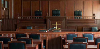 Empty courtroom with wooden furnishings and judges bench.