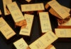 Rolex, Cash, Gold: CIA Scandal Explodes Gold bars stacked on dark background