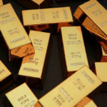 Rolex, Cash, Gold: CIA Scandal Explodes Gold bars stacked on dark background