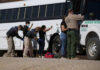 Mysterious Resignation: Truth Behind Border Chief Exit? Border patrol officers investigating people near a bus.