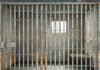 Empty rusty prison cell with a small window.