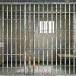 Judge APOLOGIZES to Trump Assassin — Outrage Explodes Empty rusty prison cell with a small window.