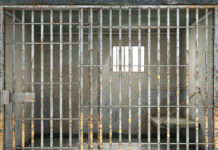 Empty rusty prison cell with a small window.