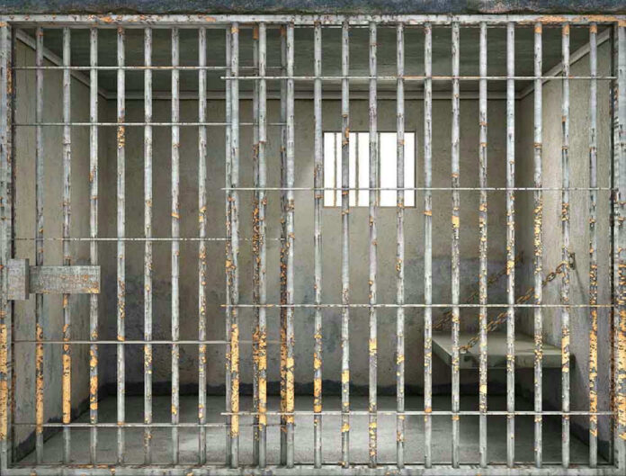 Empty rusty prison cell with a small window.