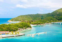 Puerto Vallarta Murders: SERIAL KILLER in Paradise? Tropical beach with docks and lush green hills.