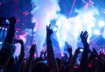 Foiled Attack: Taylor Swift Concert Terror Plot Thwarted Crowd at a concert with hands raised and smoke effects in the background