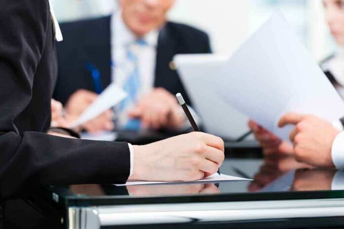 shutterstock_137911247 Close-up of a hand writing notes during a business meeting