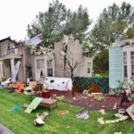Shocking Excavator Assault Amid Marital Split Houses with significant storm damage and debris scattered around the yard