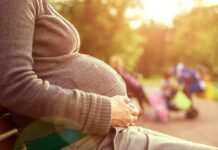 America’s Depopulation Dilemma Uncovered Pregnant woman sitting on a bench in a park during sunset