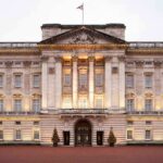 UK Police EXPAND Probe on Prince Andrew: Scandal Deepens Front view of Buckingham Palace with illuminated facade and British flag