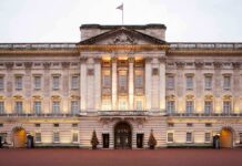 UK Police EXPAND Probe on Prince Andrew: Scandal Deepens Front view of Buckingham Palace with illuminated facade and British flag