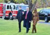 A family walking outdoors with a fire truck in the background
