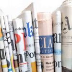 Attempt on Trump’s Life: Media to Blame? A collection of rolled newspapers displaying various headlines and designs
