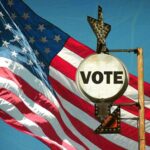 Election Scandal Looms: Los Angeles Mayor Accused! A vintage Vote sign in front of an American flag