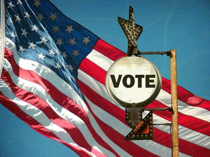 Aged,And,Worn,Vintage,Photo,Of,American,Flag,And,Vote A vintage Vote sign in front of an American flag