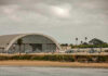 Apache Down Near Hormuz—What Aren’t We Told? Aircraft hangar with helicopters near the beach.