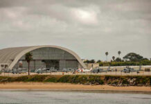 Apache Down Near Hormuz—What Aren’t We Told? Aircraft hangar with helicopters near the beach.