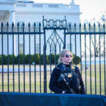 FBI Bust Widens—White House Plot Secret Service agent stands guard outside the White House.