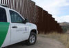 Cartel Super-Tunnel Exposed Under Suburb Border protection vehicle near a large metal fence.