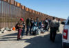 Border patrol agents interact with a group of people.