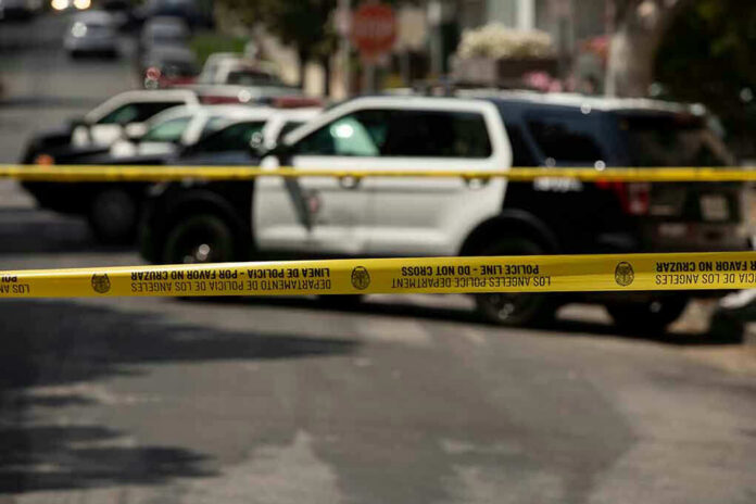 1980603047 Police tape blocking street with patrol cars.