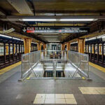 Penn Station BLOODBATH Sparks Panic Subway station platform with directional signs overhead.