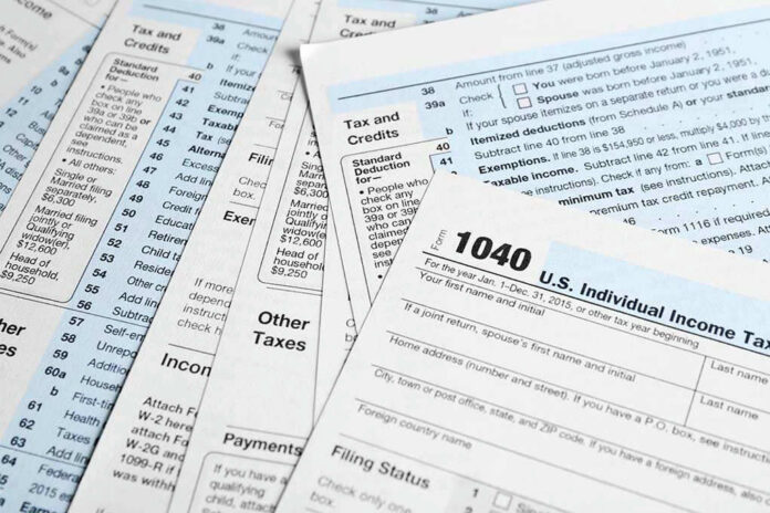 642440497 Tax forms and documents overlapping on surface