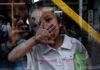 DOJ Exposes Chilling Child Smuggling Pipeline A child playfully covering their face while looking through a glass window