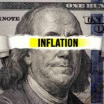 Price Spike Slams America—What’s Driving It? A torn paper strip with the word 'INFLATION' over a hundred dollar bill featuring Benjamin Franklin