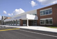 Minnesota Kid-Meal Millions: Fugitive Caught Modern school building with large windows and a clear sky
