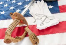 Gun Rights Showdown Inside VA Mega-Bill A military sword, dog tags, and white gloves displayed on an American flag