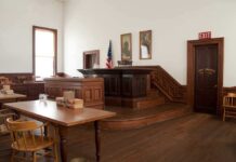 Federal Power Grab Hits Abortion Wars Interior of a historic courtroom with wooden furniture and an American flag