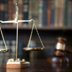 Scales of justice with gavel and books.