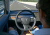 Dashboard Distraction: Lane Drift Surges Person using autopilot in Tesla on highway.