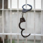 Handcuffs hanging on a barred window.