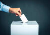 SAVE Act Shock Jolts Democrats Hand placing ballot into voting box.