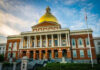 Building with golden dome and columns under a blue sky.