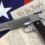 A handgun placed on top of the U.S. Constitution and an American flag