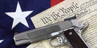 A handgun placed on top of the U.S. Constitution and an American flag