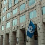 Killer’s Detainer Ignites Deportation Fight U.S. government building facade with American and blue departmental flags