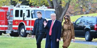 A family walking outdoors with a fire truck in the background