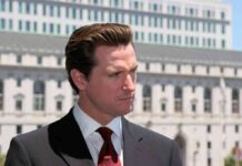 Flip-Flop Firestorm Engulfs Newsom Man in suit and red tie outdoors