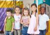 Gender Policy Uproar Slams YMCA Five children standing together in a playground setting, smiling at the camera