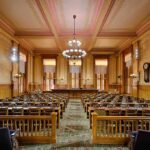 Congress Outsmarts Trump — Housing Bombshell Lands Interior view of a historic courtroom with wooden furnishings and chandeliers